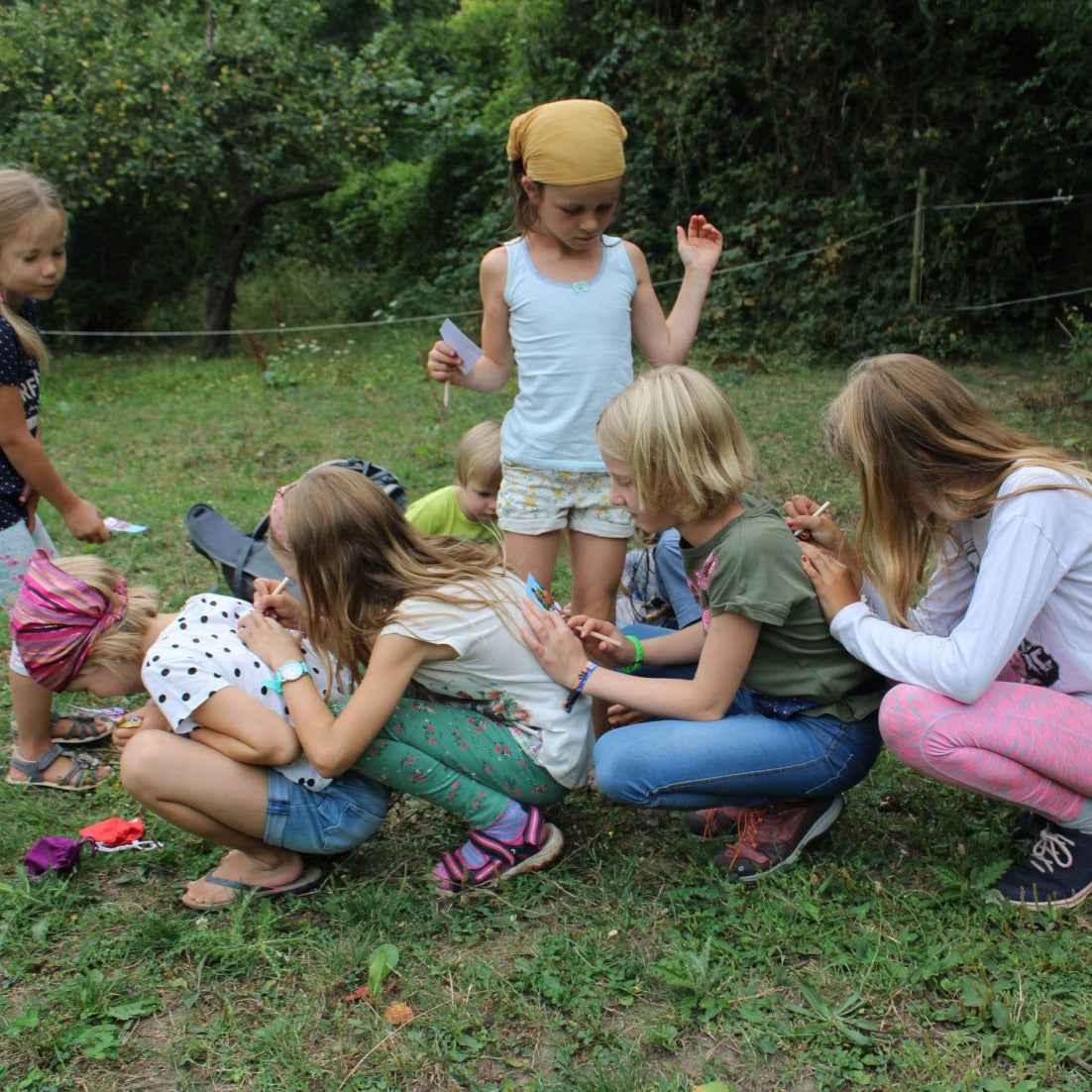 Kinder auf einem Kindergeburtstag füllen Ihre Pferdepässe aus.