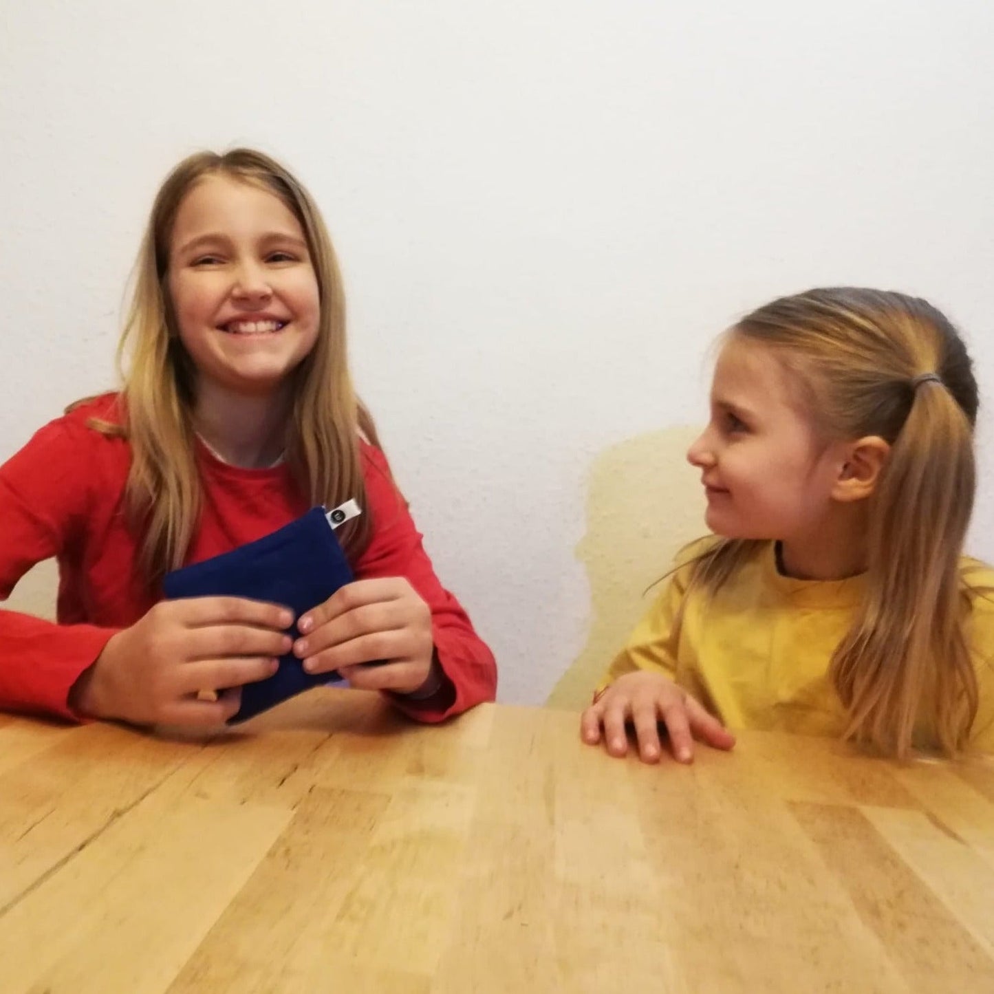 Zwei Mädchen versuchen auf einem Kindergeburtstag herauszufinden, was sich in dem Fühlsäckchen befindet.