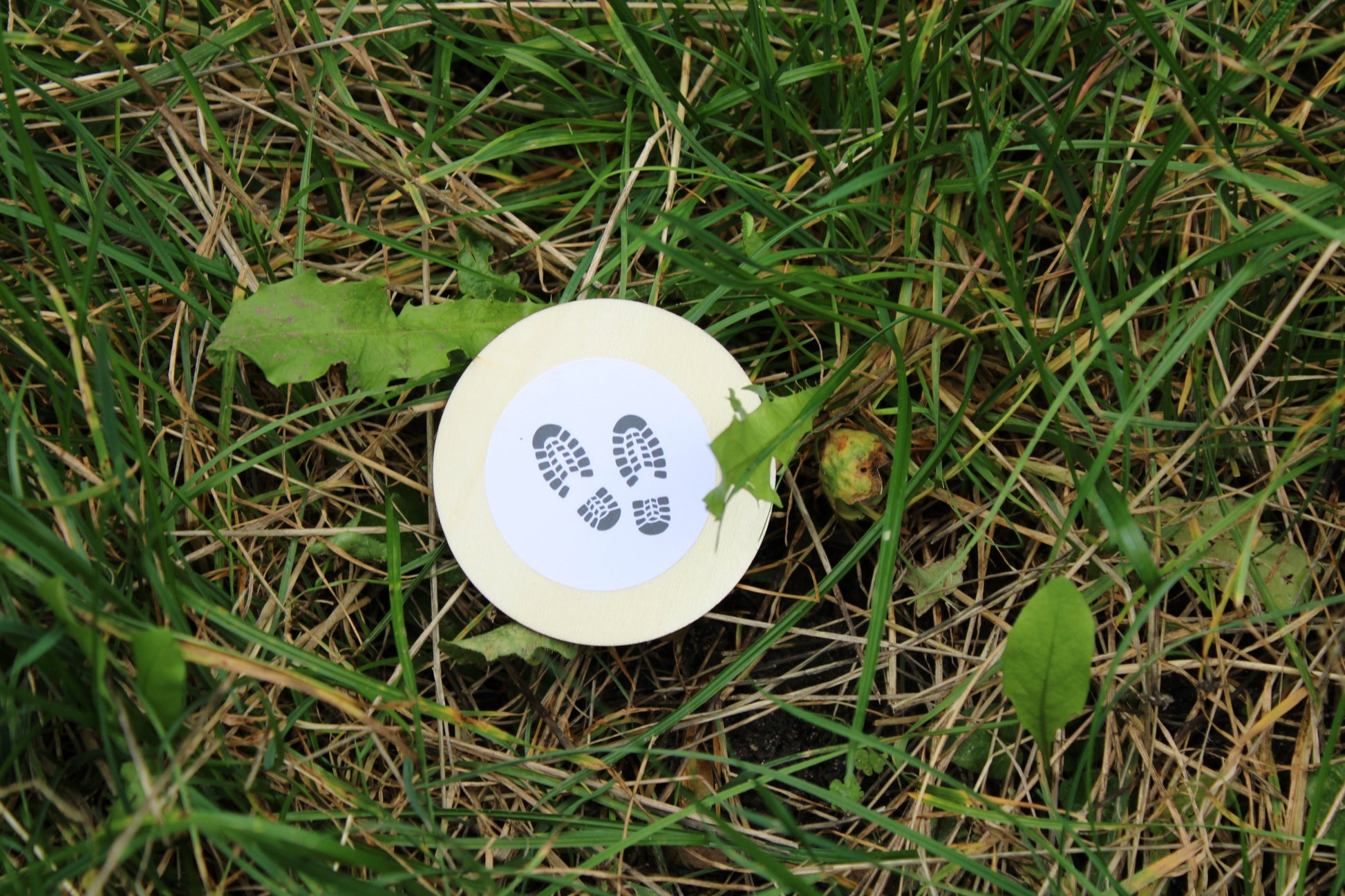Ein Fußspur aus dem Detektivrucksack liegt im Gras. Während des Geburtstages müssen diese Spuren von den Kindern gefunden werden.