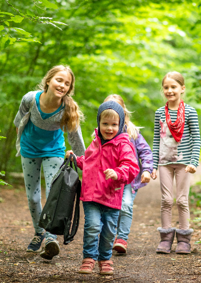 Kinder machen sich zu Beginn des Kindergeburtstages mit dem Eventrucksack auf den Weg in den Wald.